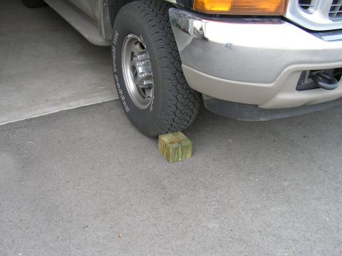 2000 Ford Excursion - Front tire of a 2000 Ford Excursion is placed on a wooden block.