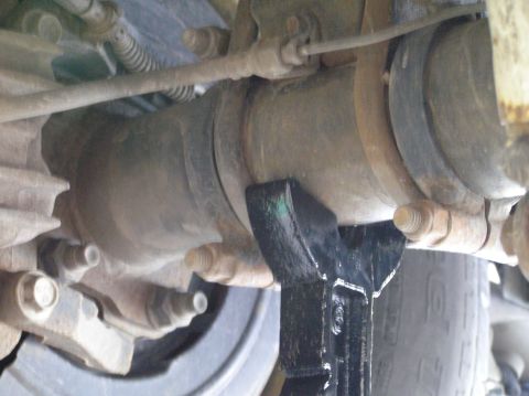 2000 Ford Excursion - Close-up view of a vehicle's rear differential assembly, supported by a jack stand during maintenance.