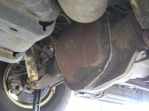 2000 Ford Excursion - Underside view of a vehicle's rear differential, showing the rusty differential cover and suspension components.