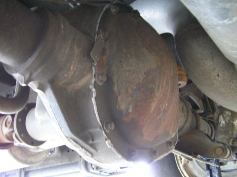 2000 Ford Excursion - Underneath view of a vehicle's rear differential housing, showing rust and bolts.