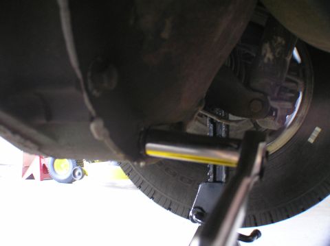 2000 Ford Excursion - Working on the rear differential fluid, using a jack and socket wrench for access.
