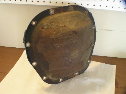 2000 Ford Excursion - A heavily rusted differential cover sits on a paper towel, showing signs of wear and tear.