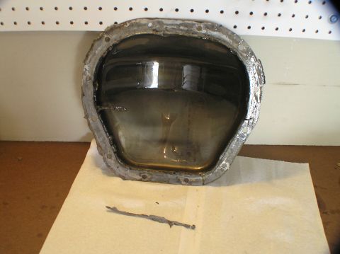 2000 Ford Excursion - A removed differential cover shows dark fluid and metal debris, indicating a need for maintenance.