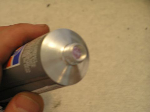2000 Ford Excursion - A tube of purple grease is held in a hand, ready for use.