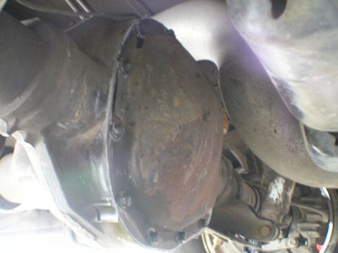 2000 Ford Excursion - Close-up of the rear differential housing and surrounding exhaust pipes on a vehicle.
