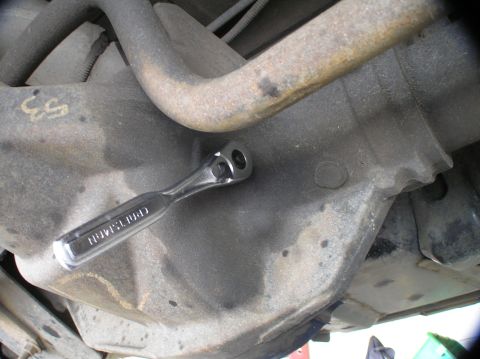2000 Ford Excursion - A ratchet is placed on a vehicle's differential housing, suggesting maintenance work.