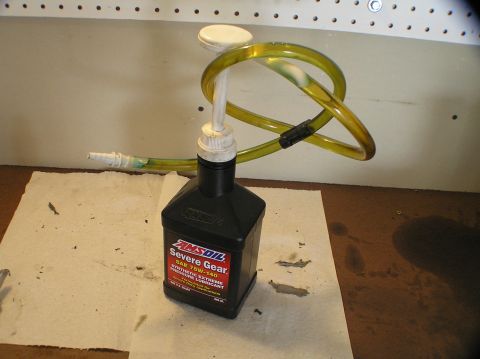 2000 Ford Excursion - AMSOIL Severe Gear oil bottle with a pump and tubing, likely for fluid transfer.