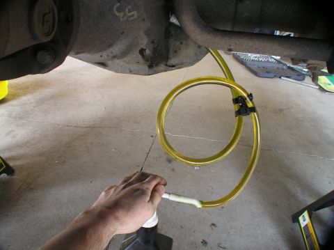2000 Ford Excursion - Filling a vehicle's rear differential with new fluid using a pump and hose.