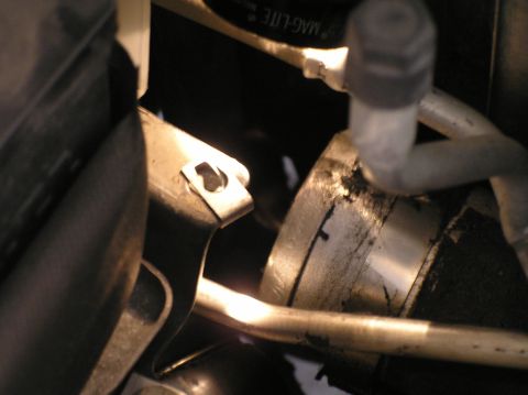 2000 Ford Excursion - A close-up view of engine components, including hoses and a metal bracket with a clip.