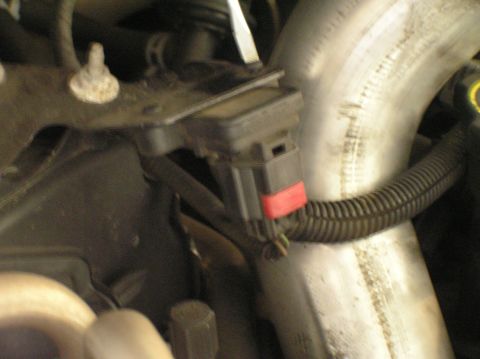 2000 Ford Excursion - Engine sensor with connector and ribbed hose attached to a large diameter intake pipe.