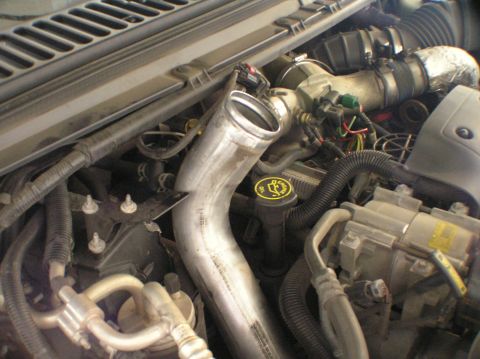 2000 Ford Excursion - Close-up of the engine bay, focusing on the intercooler piping and various engine parts.