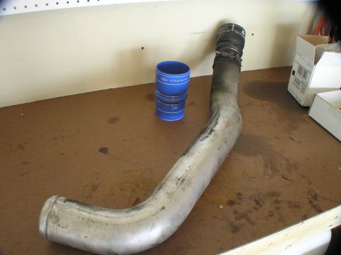 2000 Ford Excursion - Intercooler pipe and blue silicone couplers are shown on a workbench.