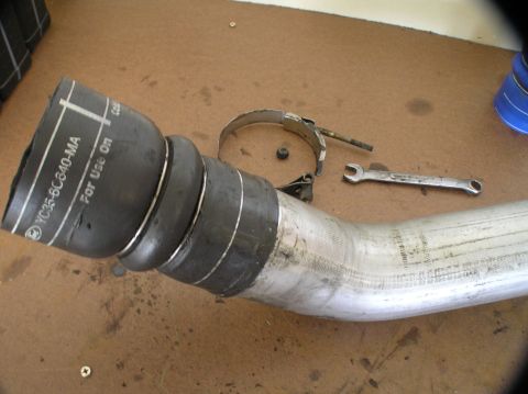 2000 Ford Excursion - Close-up of a vehicle's intercooler pipe and rubber hose assembly, with tools nearby.