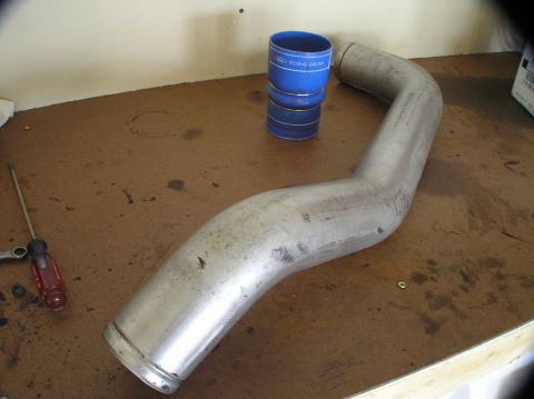 2000 Ford Excursion - Intercooler pipe and silicone couplers on a workbench, possibly for a Ford Powerstroke.