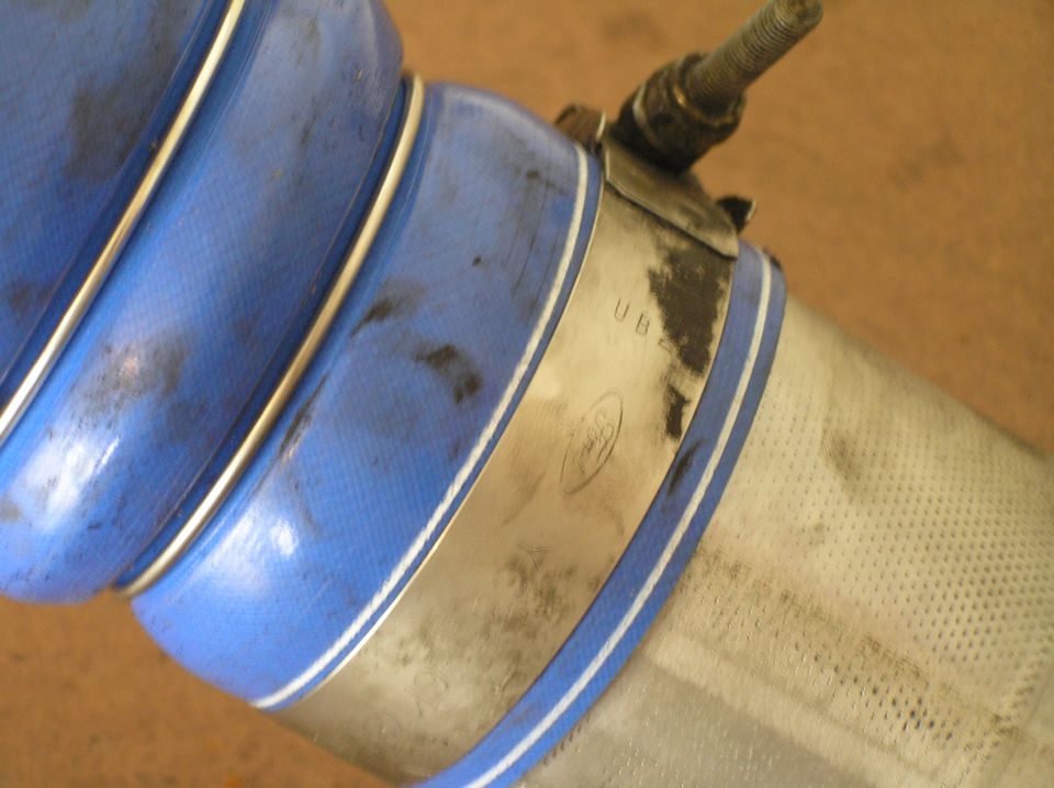 Blue silicone hose clamped to perforated stainless steel tube with metal band clamp