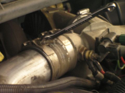 2000 Ford Excursion - Close-up of an engine component with a wrench attached, suggesting a repair or maintenance task.
