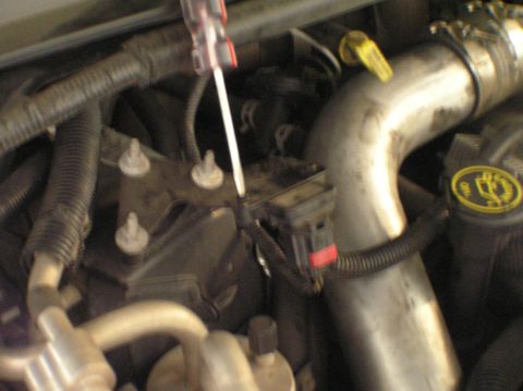 2000 Ford Excursion - Mechanic works on a sensor in the engine bay of a 2000 Ford Excursion.