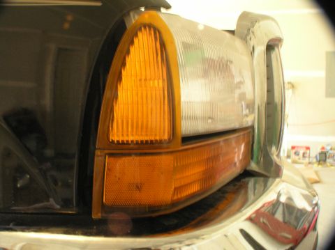 2000 Ford Excursion - Close-up of the front corner of a black Ford Excursion, showing the headlight assembly and part of the chrome bumper.
