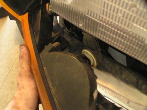 2000 Ford Excursion - A hand reaches into the front parking light assembly of a 2000 Ford Excursion, likely to replace a bulb.
