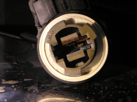 2000 Ford Excursion - A close-up view of a corroded parking light bulb socket, showing wear and tear on the electrical contacts.