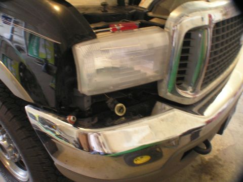 2000 Ford Excursion - Close-up of a truck's front end, focusing on the headlight assembly and chrome grille.