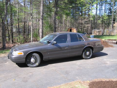 1991 Ford LTD Crown Victoria - This 1991 Ford Crown Victoria LTD is seen from the side, parked on a driveway with trees in the background.