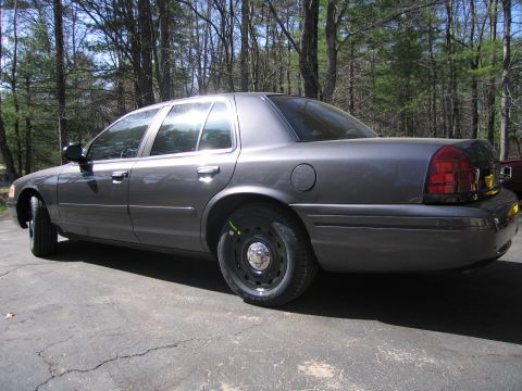 1991 Ford LTD Crown Victoria - A gray sedan is parked on a driveway with trees in the background.