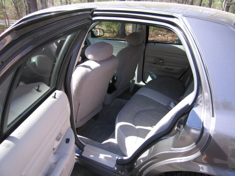 1991 Ford LTD Crown Victoria - Interior view of a sedan, showing the rear seats and door panels with sunlight illuminating the cabin.