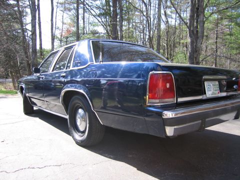 1991 Ford LTD Crown Victoria - Rear view of a 1991 Ford Crown Victoria LTD sedan parked on a driveway with trees in the background.