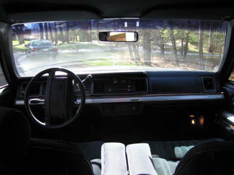 1991 Ford LTD Crown Victoria - View from the driver's seat shows the dashboard and a car driving away on a sunny day.