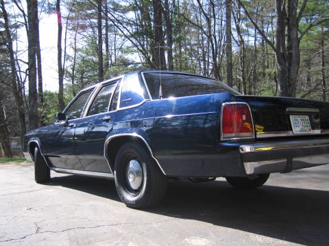 1991 Ford LTD Crown Victoria - Rear 3/4 view of a dark blue 1991 Ford Crown Victoria LTD sedan parked outdoors.