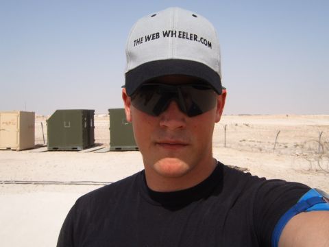 1988 Ford Bronco - A man poses for a selfie in a desert environment, with military containers in the background.