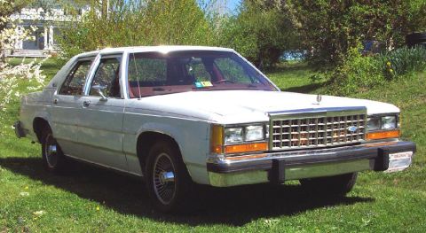 1985 Ford Crown Victoria LTD - This 1985 Ford Crown Victoria LTD is seen from a 3/4 front angle, parked on a grassy lawn.