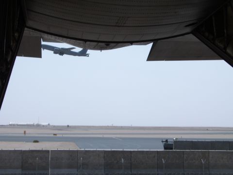 1988 Ford Bronco - An airplane ascends into the sky, captured from the perspective of a cargo bay, with an airport tarmac visible below.