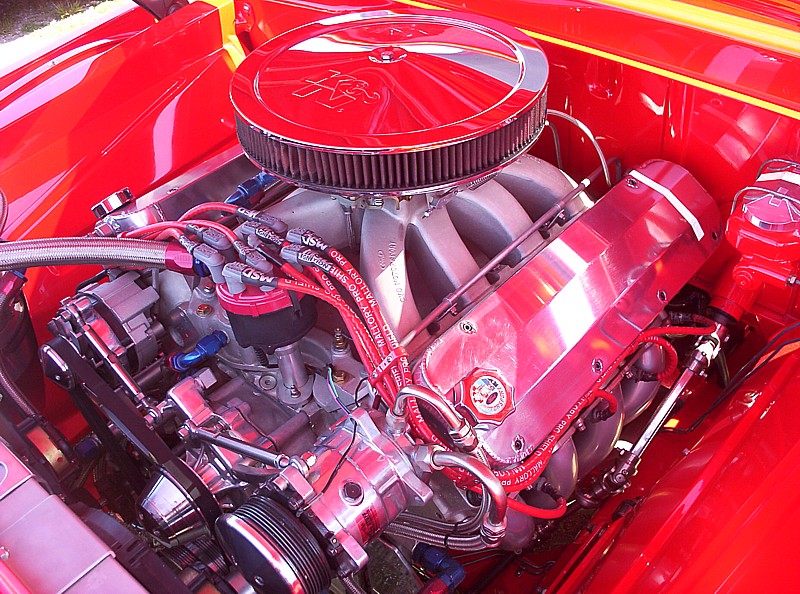 Close-up of a shiny red V8 engine with chrome parts and red spark plug wires