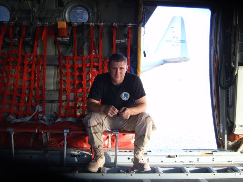 1988 Ford Bronco - A man sits in the back of a cargo plane, with another aircraft visible outside.