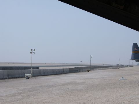 1988 Ford Bronco - A wide view of an airport tarmac with concrete barriers and the tail of an aircraft visible on the right.