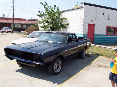 1969 Ford Ranchero - A dark blue pickup truck is parked in a lot next to another vehicle.