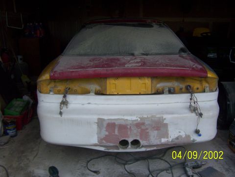 1994 Ford Probe - The rear of a car is shown with an unfinished bumper and exposed trunk lid, suggesting ongoing bodywork.