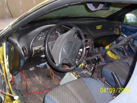 1994 Ford Probe - The interior of a 1994 Ford Probe shows exposed wiring and a GT badge on the dashboard.