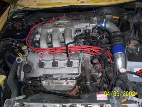 1994 Ford Probe - The engine bay of a 1994 Ford Probe shows a V6 engine with red spark plug wires and a date stamp of 04/09/2002.