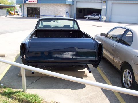 1969 Ford Ranchero - The rear of a dark blue pickup truck is shown, with its bed empty and taillights removed.