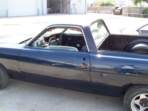 1969 Ford Ranchero - A dark blue 1969 Ford Ranchero is shown from the side, with its driver's side door handle and mirror removed.