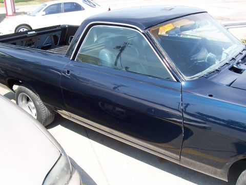 1969 Ford Ranchero - Side view of a 1969 Ford Ranchero with dark blue paint, parked outdoors.