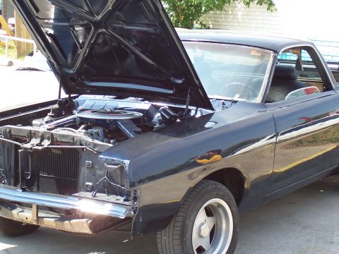 1969 Ford Ranchero - This black pickup truck has its hood open, revealing the engine compartment after a fresh paint job.