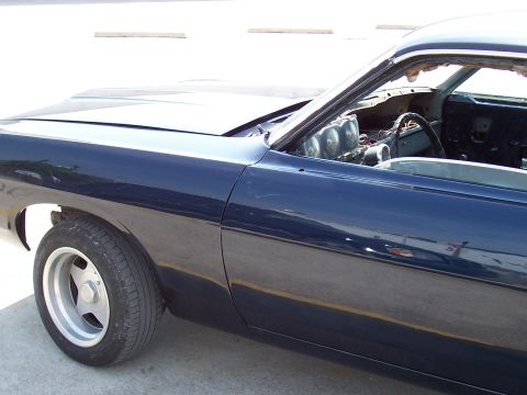 1969 Ford Ranchero - This 1969 Ford Ranchero features a dark blue paint job, custom wheels, and aftermarket interior gauges visible through the open window.