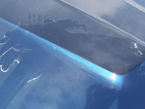 1969 Ford Ranchero - The blue paint on the car hood shows some scuffs and reflections from the surroundings.