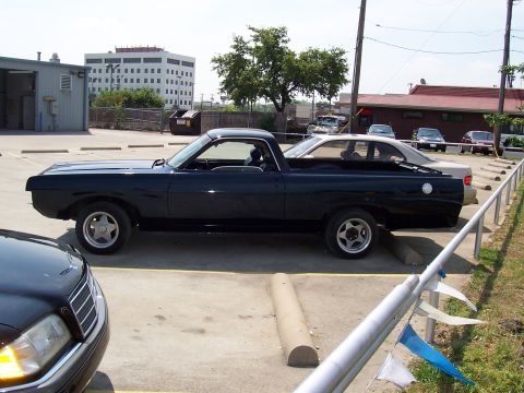 1969 Ford Ranchero - Side view of a black 1969 Ford Ranchero parked in a lot with other vehicles.