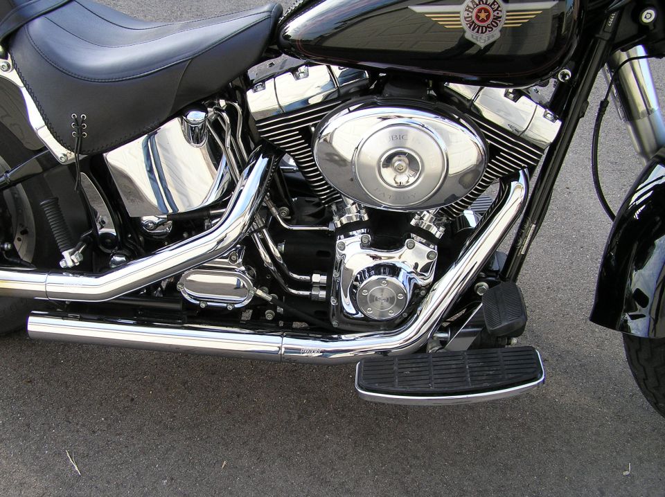 Chrome V-twin engine and exhaust on black Harley-Davidson Fat Boy motorcycle