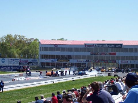 1978 Ford F-250 - A drag racing event is underway with cars on the track and spectators watching from the stands.